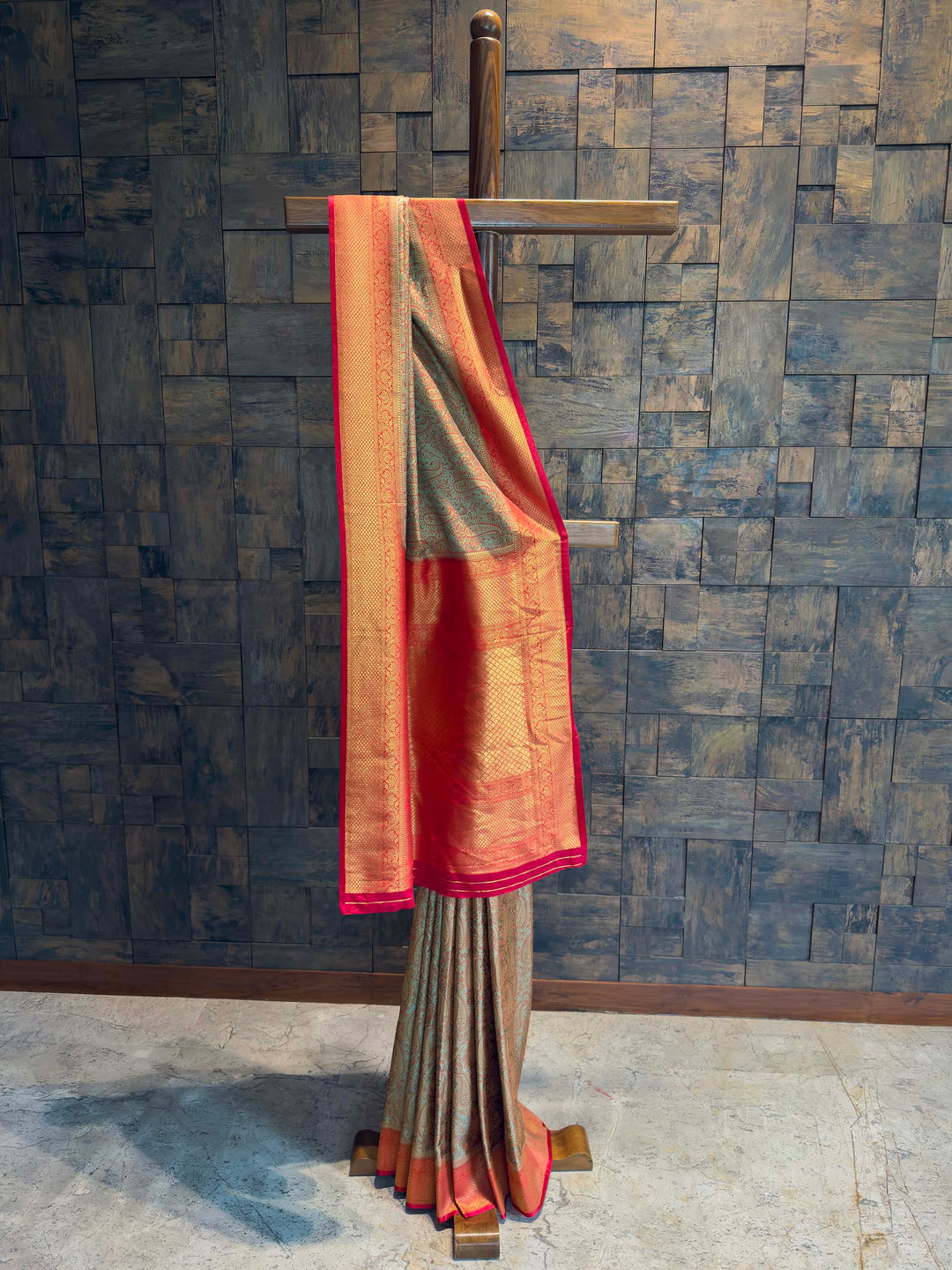 Full drape view of Metallic Olive Grey Tanchoi Satin Silk saree with Red border on mannequin.