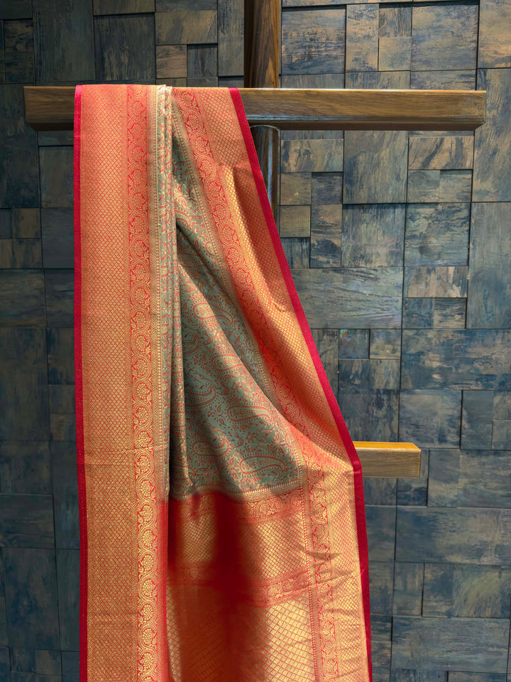 Close-up of the bronze-grey satin body showing teal woven paisley motifs.