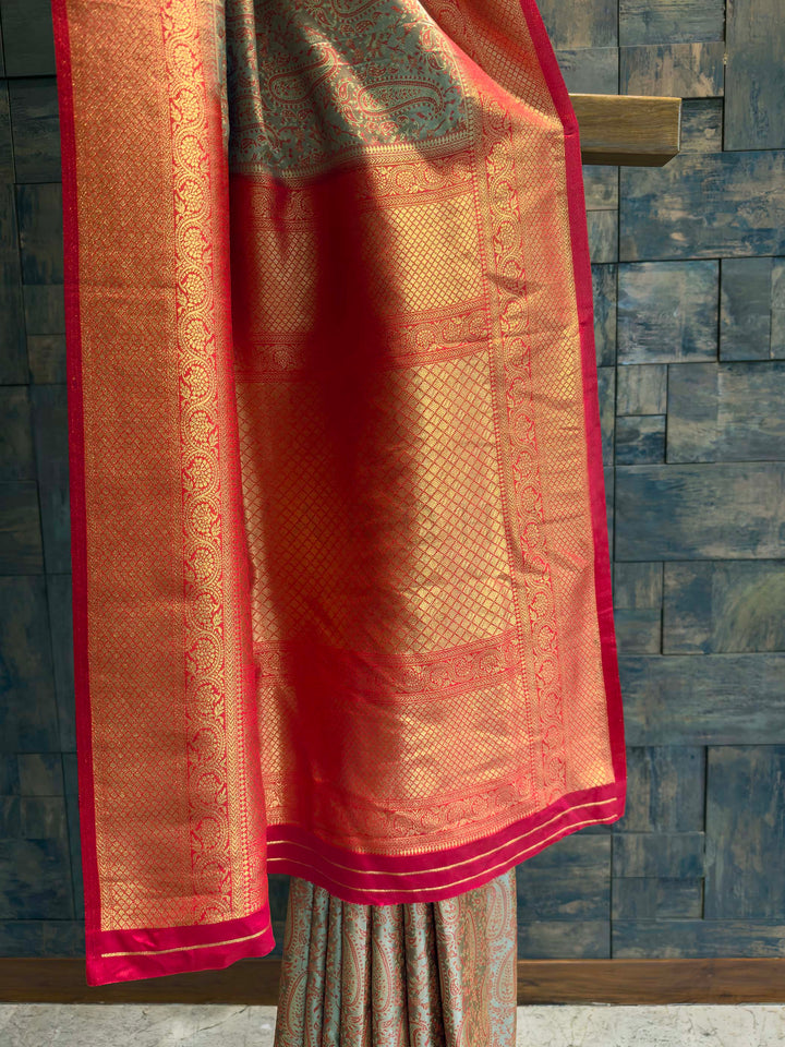 Detail shot of the Deep Red Gold Zari border contrasting with the metallic body.
