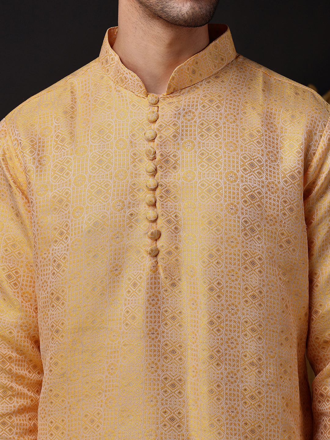 Close-up of the detailed jacquard pattern and the long, elegant placket of potli buttons
