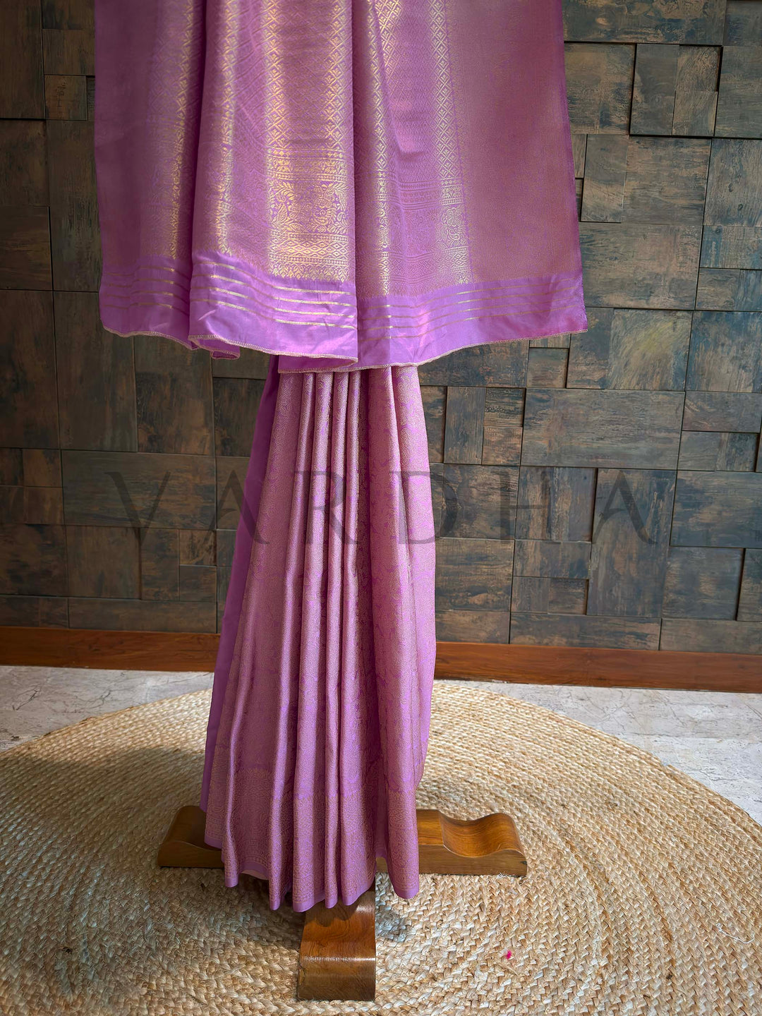 Lower hem view featuring diamond brocade border and multilayered zari patterning in gold on lilac-pink art silk.