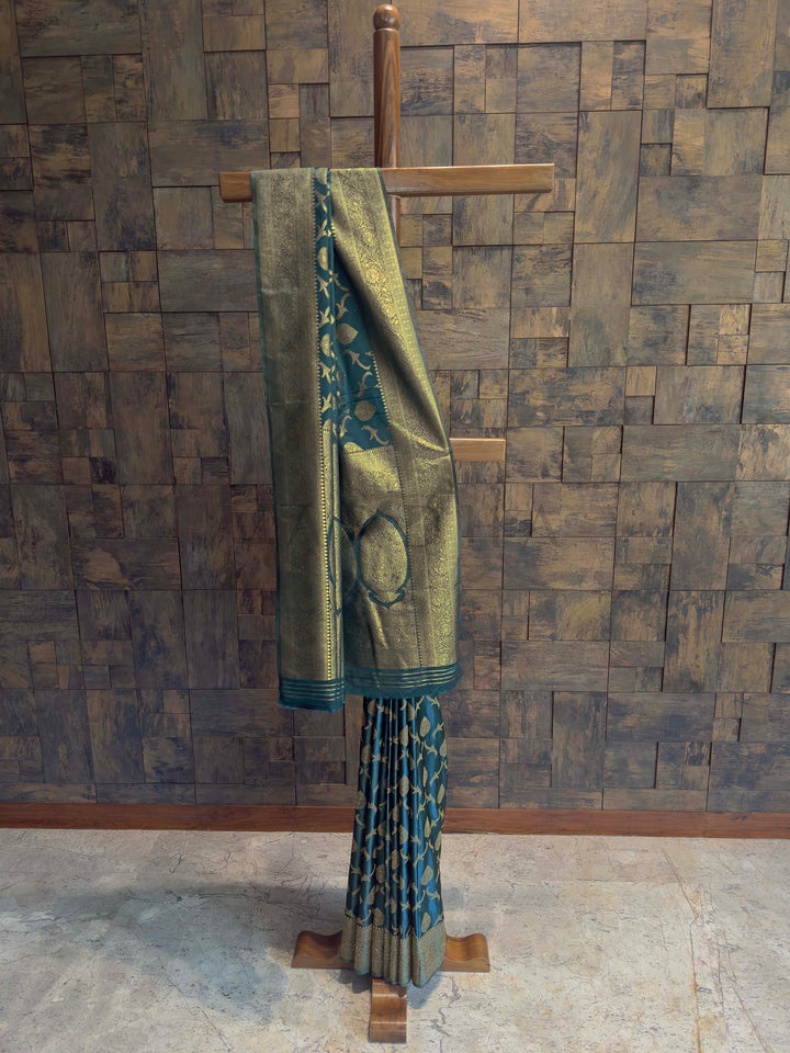 Peacock Blue Golden Zari Banarasi Satin Silk Saree House of Vardha. House of Vardha designer Peacock Blue Golden Zari Banarasi Satin Silk Saree featuring traditional golden zari buttis across the body and a heavy, decorative pallu. We offer Ready to wear, Pre drape service, Saree Add on, Custom Stitched Blouse, Fall and Edging, Gift Packaging at Complimentary Price!
