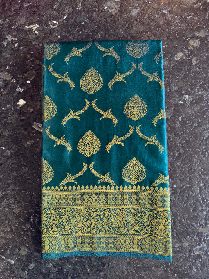 Peacock Blue Golden Zari Banarasi Satin Silk Saree House of Vardha. Beautifully draped Peacock Blue Golden Zari Banarasi Satin Silk Saree showcasing the soft fall of the fabric and the glimmer of the woven patterns by House of Vardha. We offer Ready to wear, Pre drape service, Saree Add on, Custom Stitched Blouse, Fall and Edging, Gift Packaging at Complimentary Price!. Authentic Indian ethnic wear featuring a striking Peacock Blue Golden Zari Banarasi Satin Silk Saree richly woven with golden threads to cr