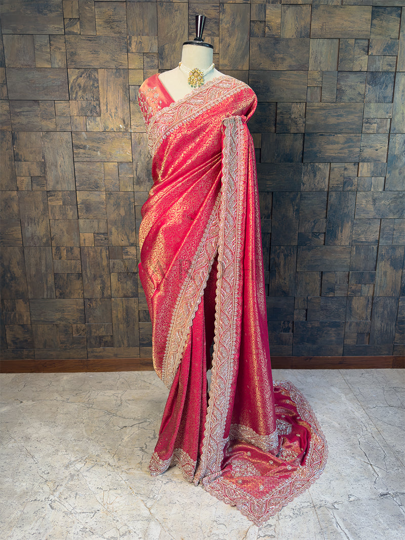 Pink saree with gold patterns on a mannequin against a textured wall. Full View Bridal Rani Pink Kanjivaram Silk Saree with Stone Handwork