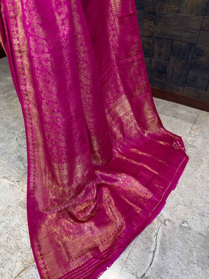 Pink fabric with gold patterns on a stone floor. Luxurious Indian bridal Pink Kanjivaram Silk Saree with Zari Weave from House of Vardha with heavy gold embellishments. We offer Ready to wear, Pre drape service, Saree Add on, Custom Stitched Blouse, Fall and Edging, Gift Packaging at Complimentary Price!