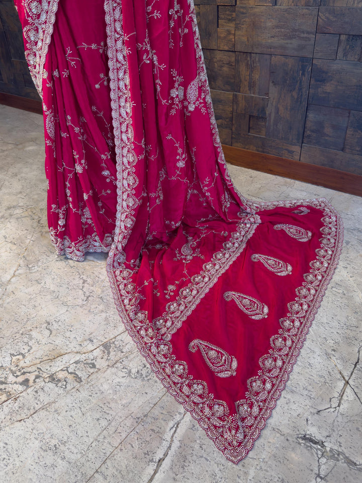 Heavy Embroidered Paisley Pallu on Pink Party Saree. Luxurious Pink festive Satin Crepe Saree from House of Vardha featuring radiant beadwork and stone embellishments, perfect for glamorous evening parties and weddings. We offer Ready to wear, Pre drape service, Saree Add on, Custom Stitched Blouse, Fall and Edging, Gift Packaging at Complimentary Price!