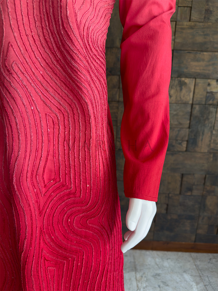 pink textured dress on a mannequin against a wooden paneled wall. Close-up of the kurta sleeve showing the detailed, continuous swirling cord pattern on the premium pink viscose fabric.