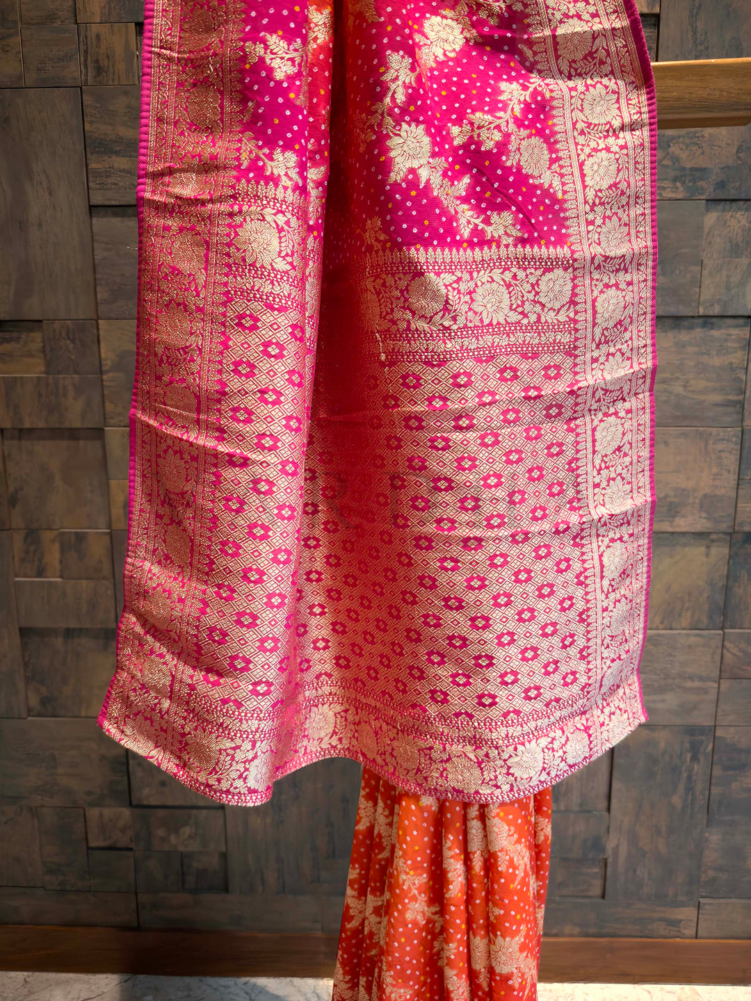 Traditional pink and orange patterned fabric draped over a wooden surface.