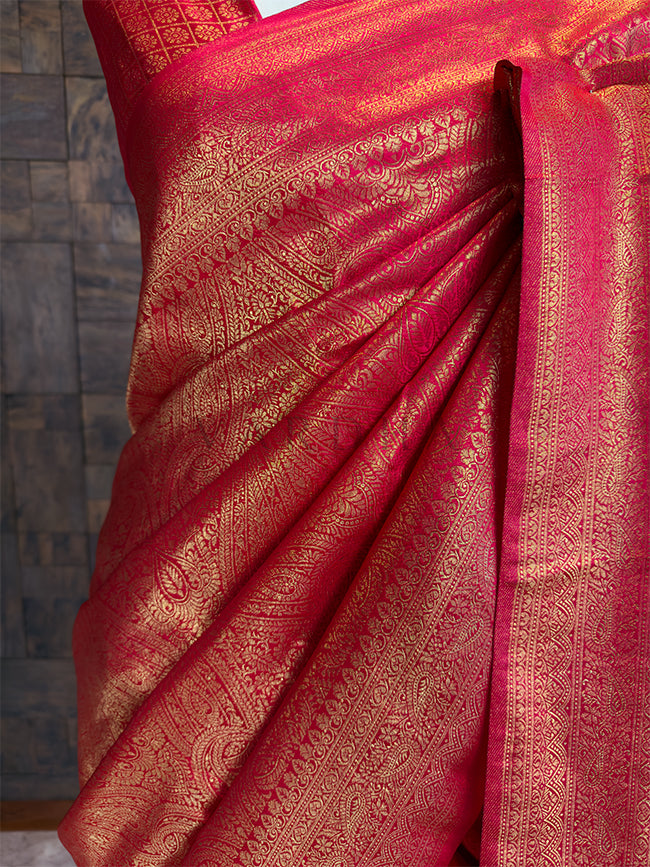 Red saree with gold patterns on a textured surface. Rich Crimson-Red Saree in Pure Silk with Ornate Gold Border and Diamond Pattern Pallu, House of Vardha
