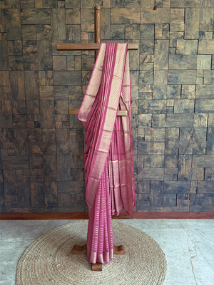 Rose pink georgette saree with zari striped motifs, diamond jaal border, and paisley-floral pallu for festive celebrations