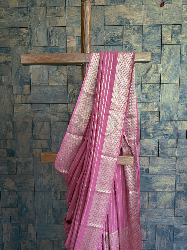 Detailed view of zari diamond jaal weave and paisley-floral butas on rose pink georgette saree for pooja or gifting