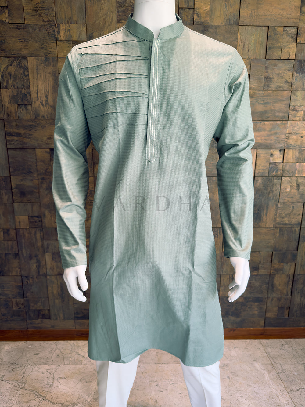 Close-up of the dusty blue-green men's festive kurta showcasing the fine micro-texture, unique chest pleating, and a concealed placket with contrast triple-stitch detailing.