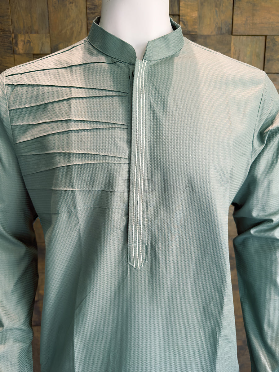 Sage Blue kurta on a mannequin against a wooden background Detailed chest view highlighting the crisp mandarin collar, horizontal pintucks, and embroidered concealed placket on the premium sage blue cotton designer kurta for men.