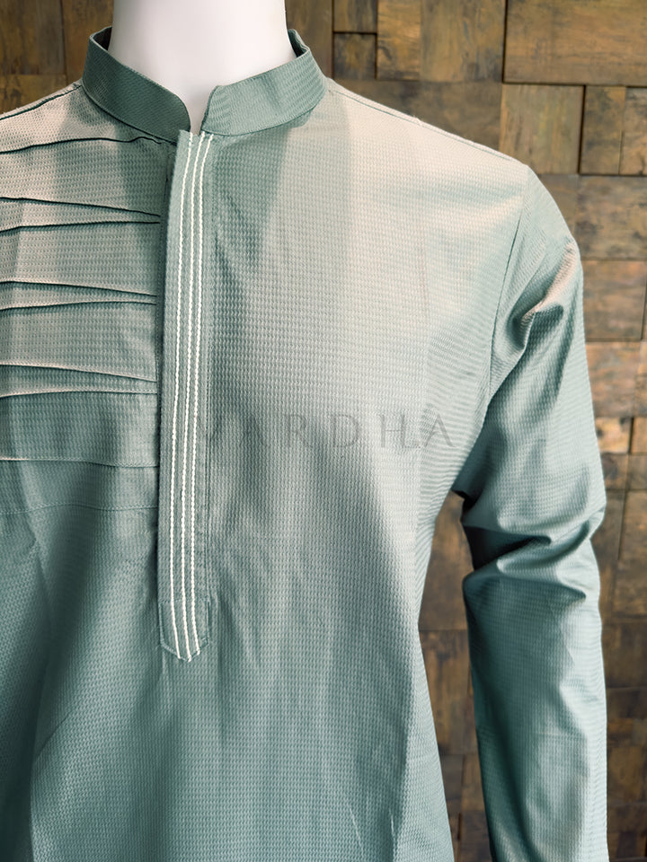 Blue kurta on a mannequin against a wooden background. Side angle of the tailored blue-grey cotton kurta for men, emphasizing the structured fit, woven texture, and modern asymmetrical chest design ideal for sophisticated evening wear.