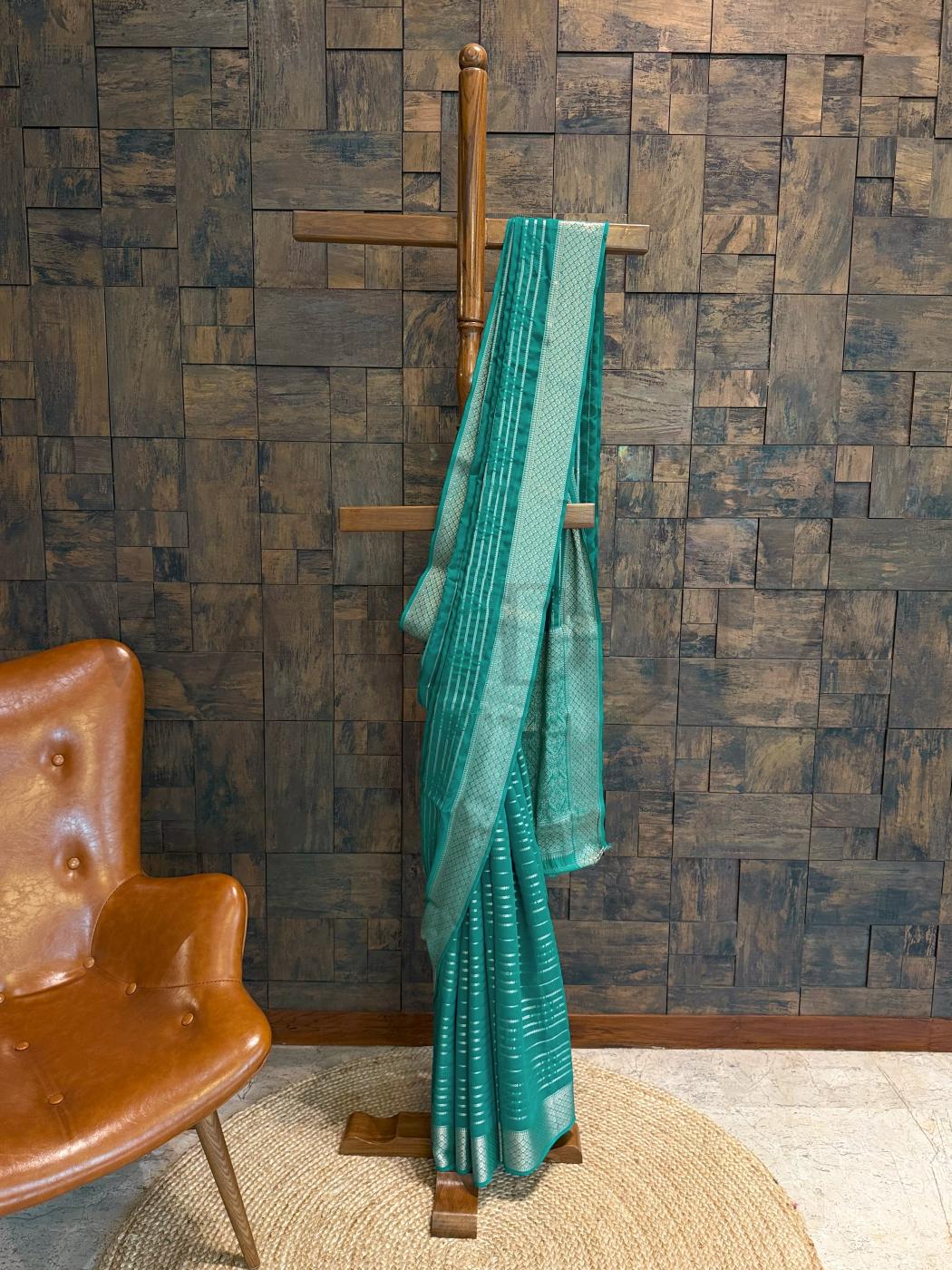 Seagreen feathersoft georgette saree with golden striped zari work displayed on hanger for festive ethnic styling. - Side view of teal georgette saree showcasing shimmering gold zari stripes and soft structured fall