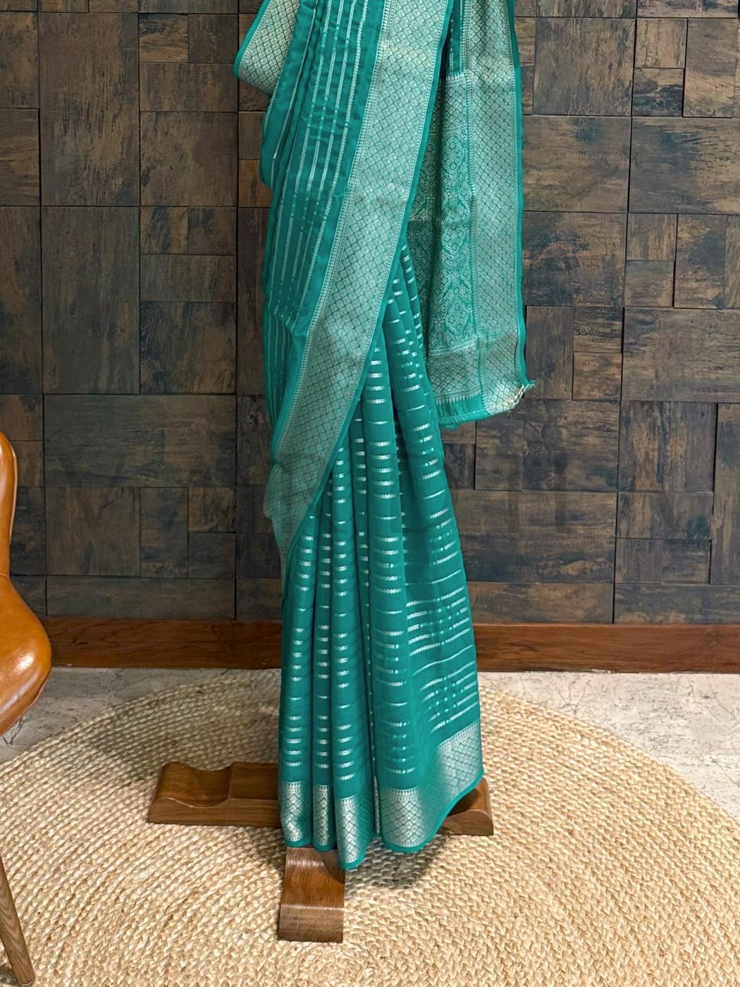 Teal georgette saree texture highlighting featherlight softness and golden woven zari for elegant appeal. - Golden pallu design in zari over teal base for ethnic events - captured in flowing georgette fabric