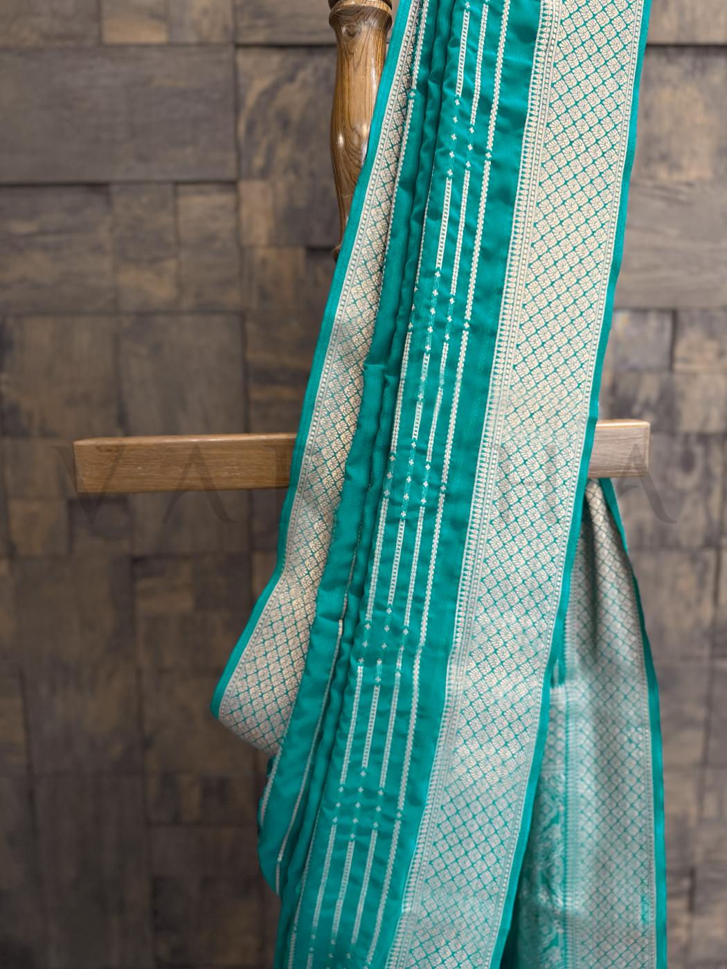  Saree pleats in teal and gold with bandhani-style zari stripes ideal for poojas - mehendi - and temple wear. - Matching unstitched blouse with golden zari border - perfect for festive pairing with teal saree ensemble