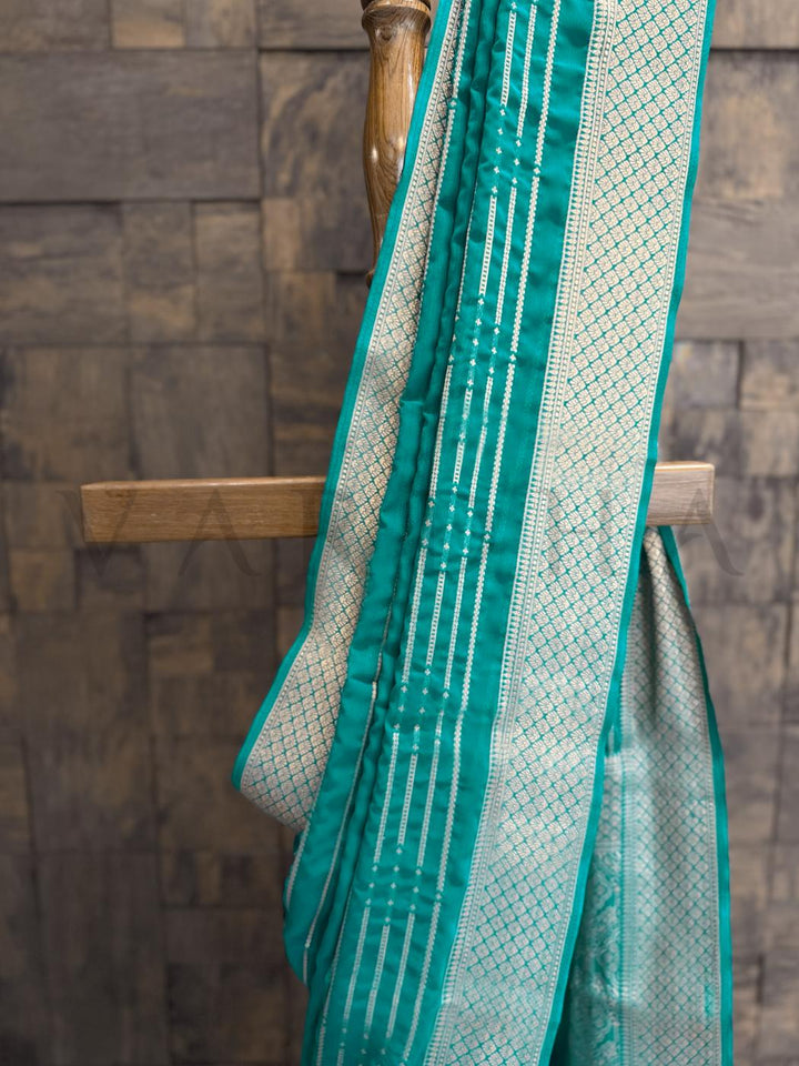  Saree pleats in teal and gold with bandhani-style zari stripes ideal for poojas - mehendi - and temple wear. - Matching unstitched blouse with golden zari border - perfect for festive pairing with teal saree ensemble
