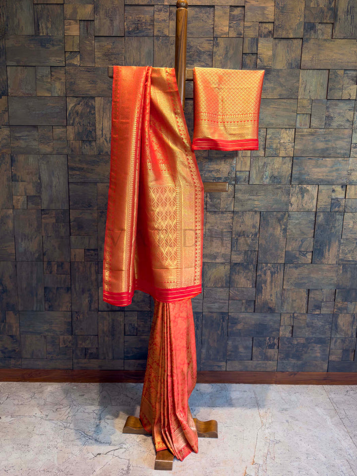 Traditional saree with a gold border on a textured wall background Full-length drape of Sindoori red golden zari Kanjivaram saree on stand