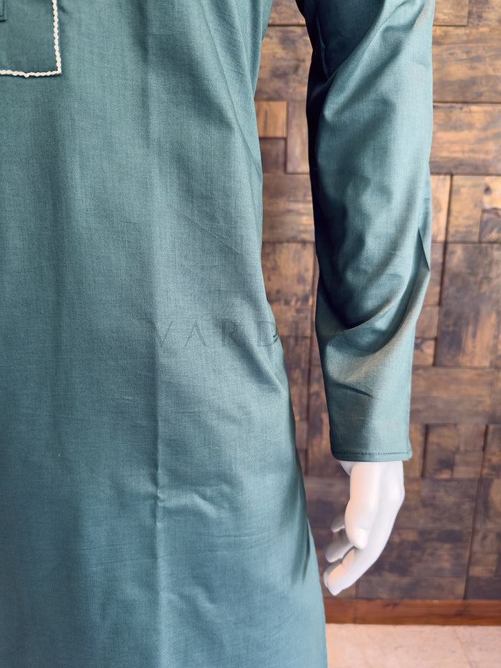 Green long-sleeve shirt on a wooden background. Elegant Slate Green designer kurta for festive brunches and morning pujas, featuring a sophisticated earthy silhouette and full sleeves.