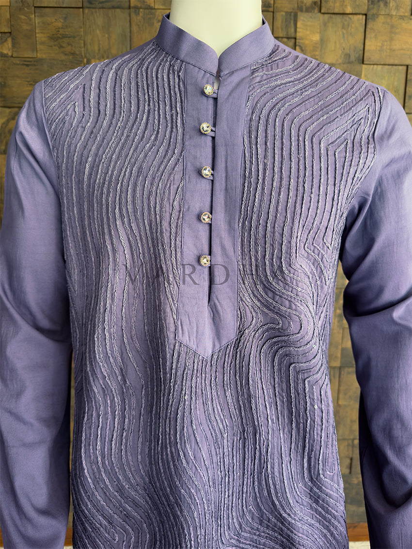 Purple kurta with intricate patterns on a wooden background. Close-up of the steel grey men&