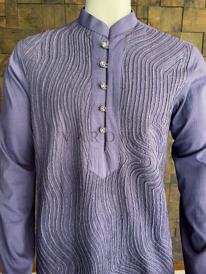 Purple kurta with intricate patterns on a wooden background. Close-up of the steel grey men&