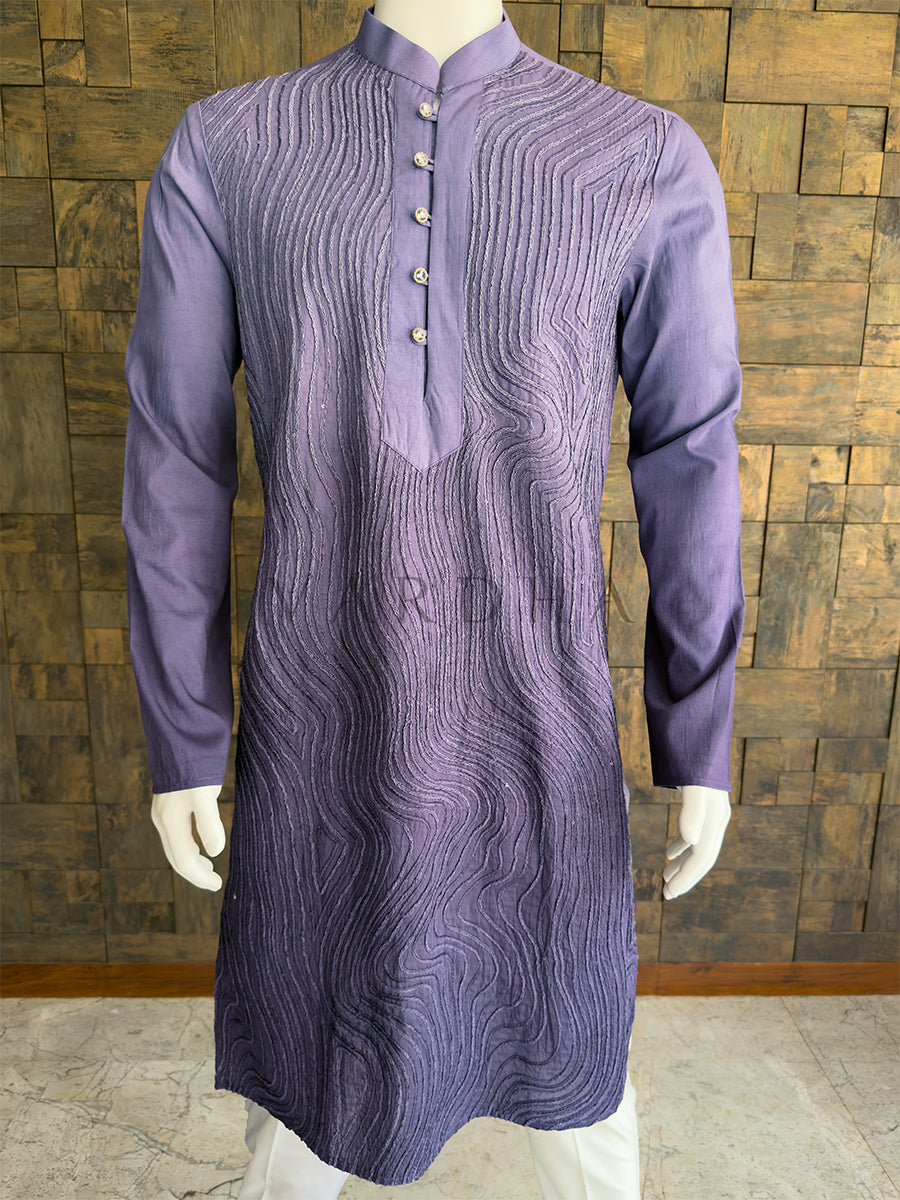 Purple kurta on a mannequin against a wooden paneled wall. Close-up of the kurta sleeve showing the detailed, continuous swirling cord pattern on the premium slate grey viscose fabric. Exquisite tailored ethnic wear offering a luxurious alternative to silk for special events.