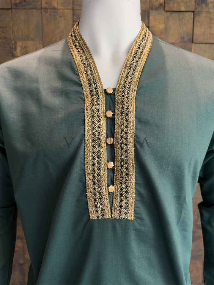 teal blue kurta with gold embroidery on a wooden background. Close-up of a designer teal kurta showing the sleek V-neck design and flat metallic gold buttons that provide a luxurious touch to the minimalist fabric.