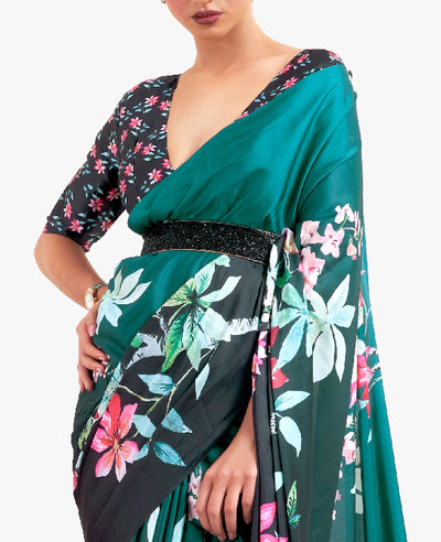 Chic teal green-black digital printed crepe saree with Bollywood-style drape and floral motifs, perfect for parties and gatherings.