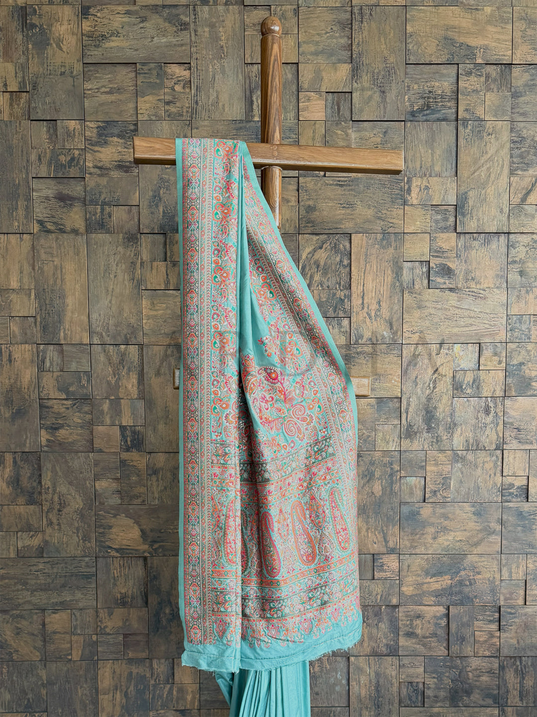 Turquoise-blue raw silk saree with a soft Pashmina finish and exquisite embossed thread work, ideal for festive and formal occasions.