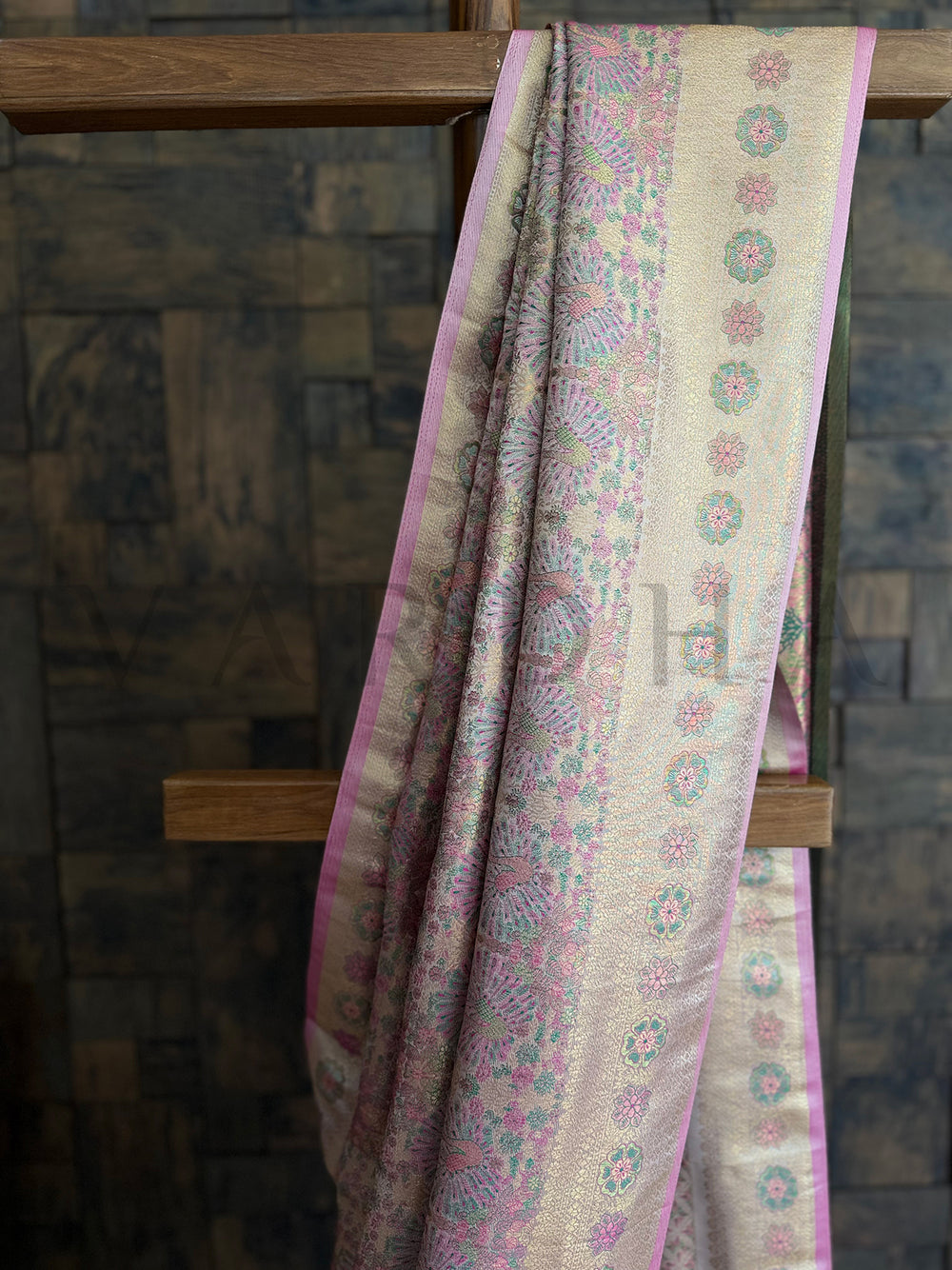 Traditional white woven saree with intricate floral Kalamkari print and contrast blouse. Soft white saree with luxurious pink border and gold zari accents for festive wear.
