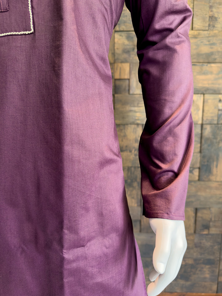 Close-up of a purple garment with a textured wooden background. Elegant jewel-toned Wine kurta for evening receptions and festive gatherings, highlighting a sophisticated silhouette and full sleeves.
