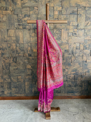 Elegant wine-hued pashmina raw silk saree adorned with intricate embossed thread work, perfect for a regal look.