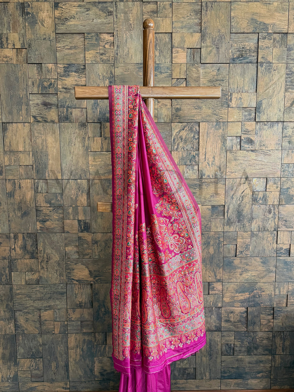 Sophisticated wine-colored raw silk saree featuring fine pashmina texture and exquisite embossed thread work