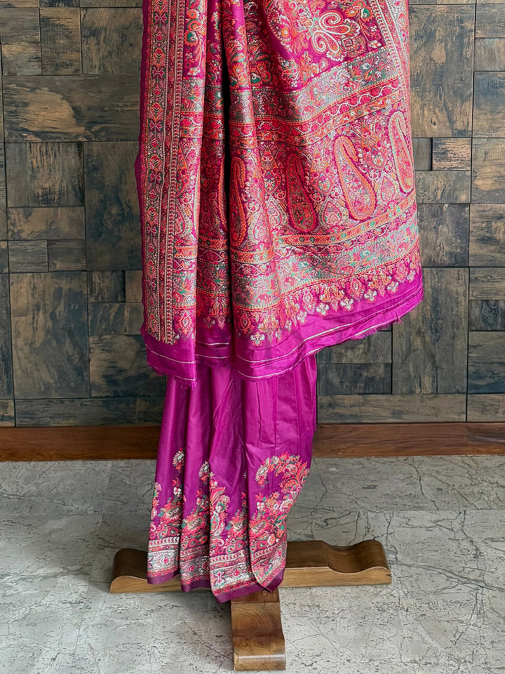 Opulent wine-toned pashmina raw silk saree, beautifully crafted with intricate embossed thread embroidery for a refined finish.