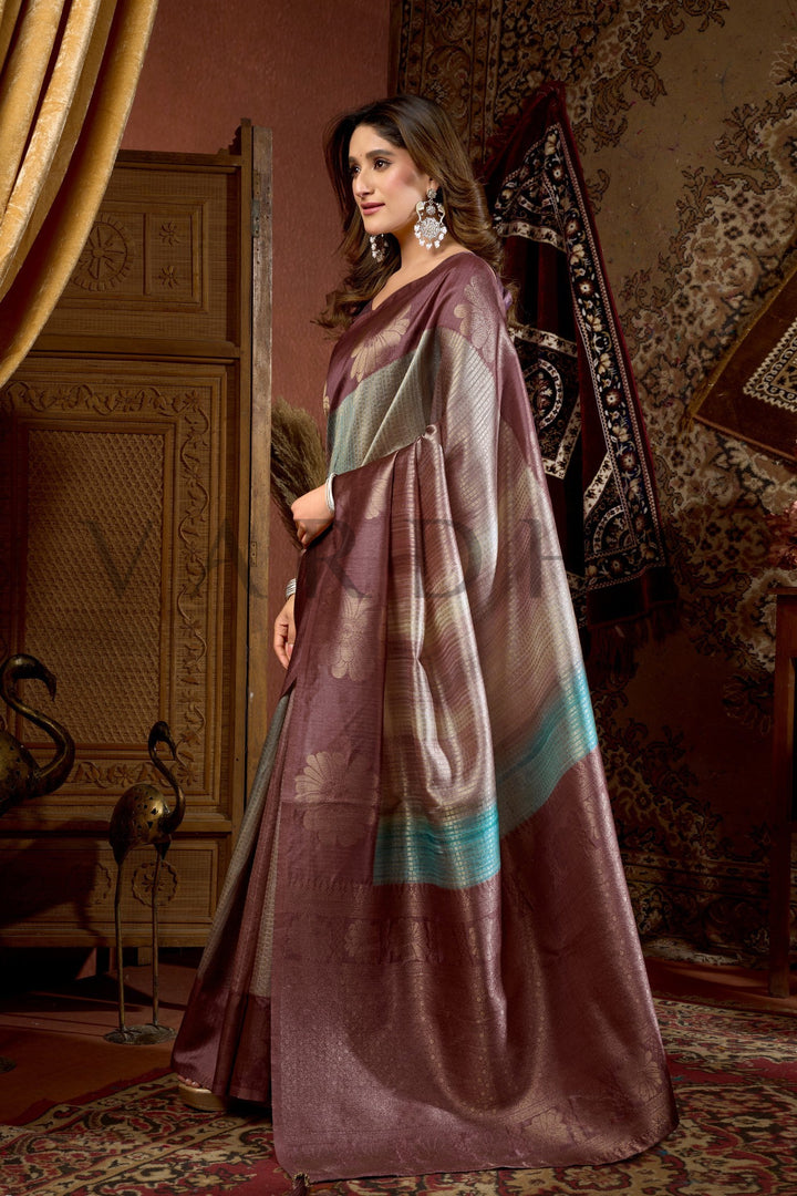 Woman wearing a traditional saree in an ornate room.Experience the perfect blend of traditional craftsmanship and contemporary style with this premium Prijam Kota Silk Saree.