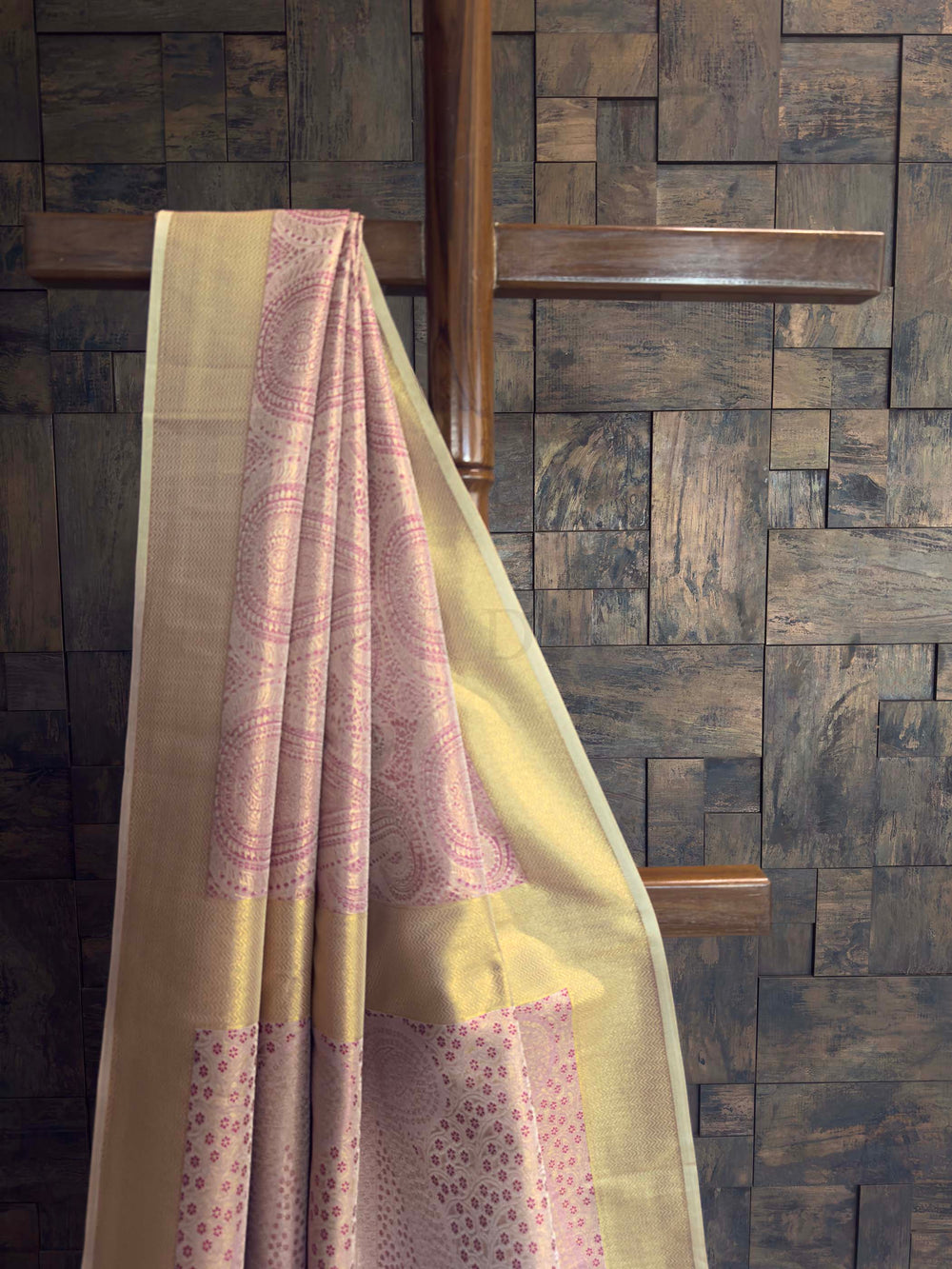 Light-colored fabric with a subtle pattern draped over a wooden structure against a stone wall.