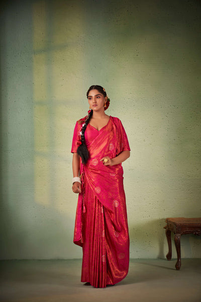 Model styled in vibrant pink saree with statement jewelry.