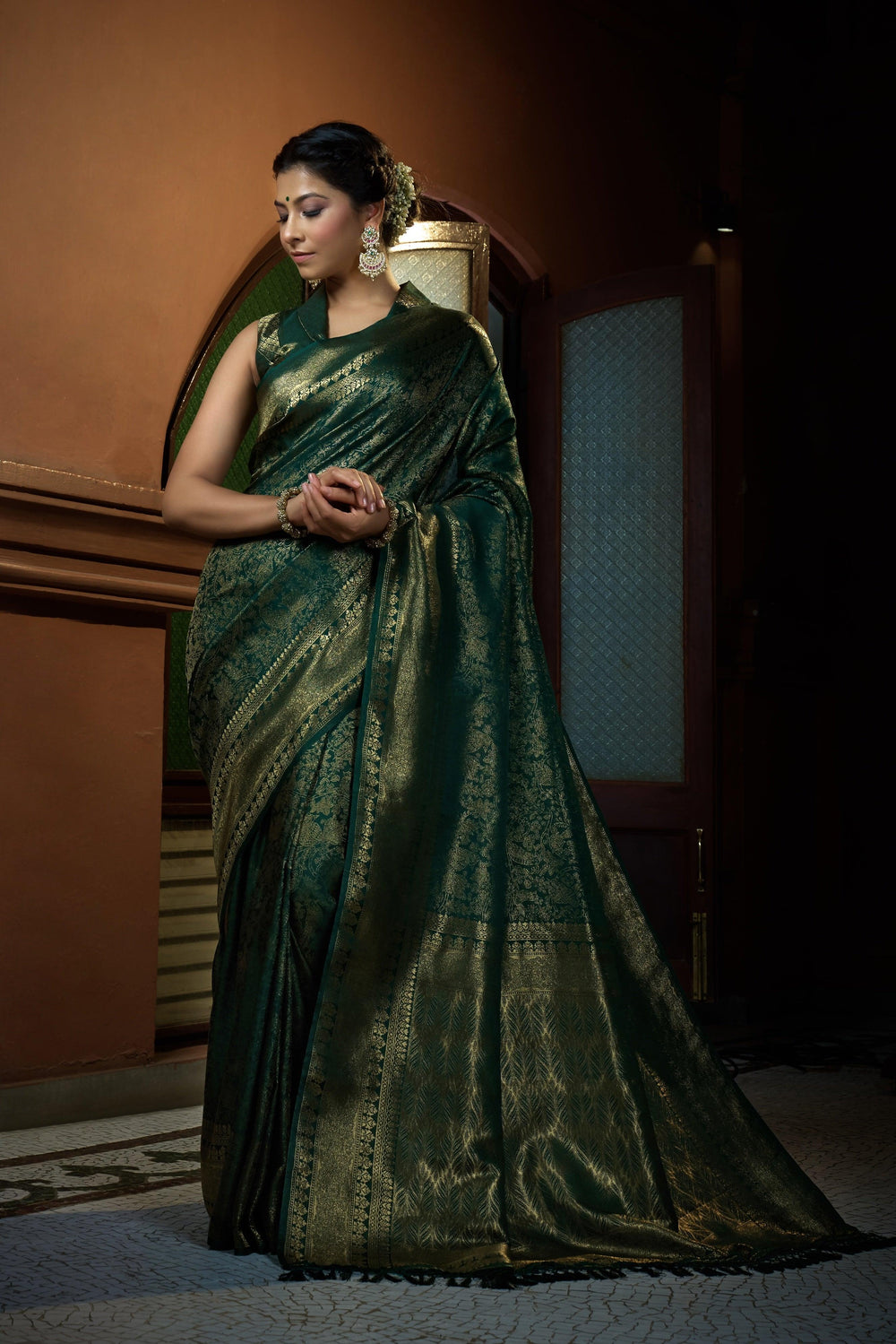 Traditional animal-inspired zari motifs on the green silk fabric.