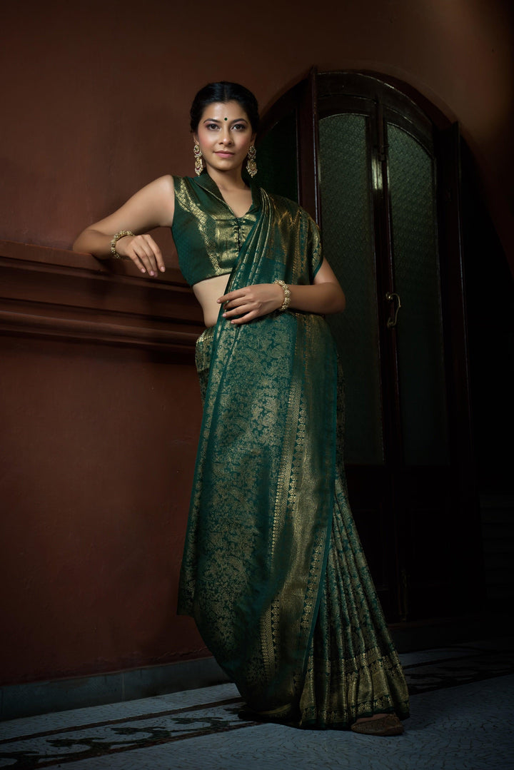 Flat lay of saree with blouse piece, highlighting texture and intricate craftsmanship.