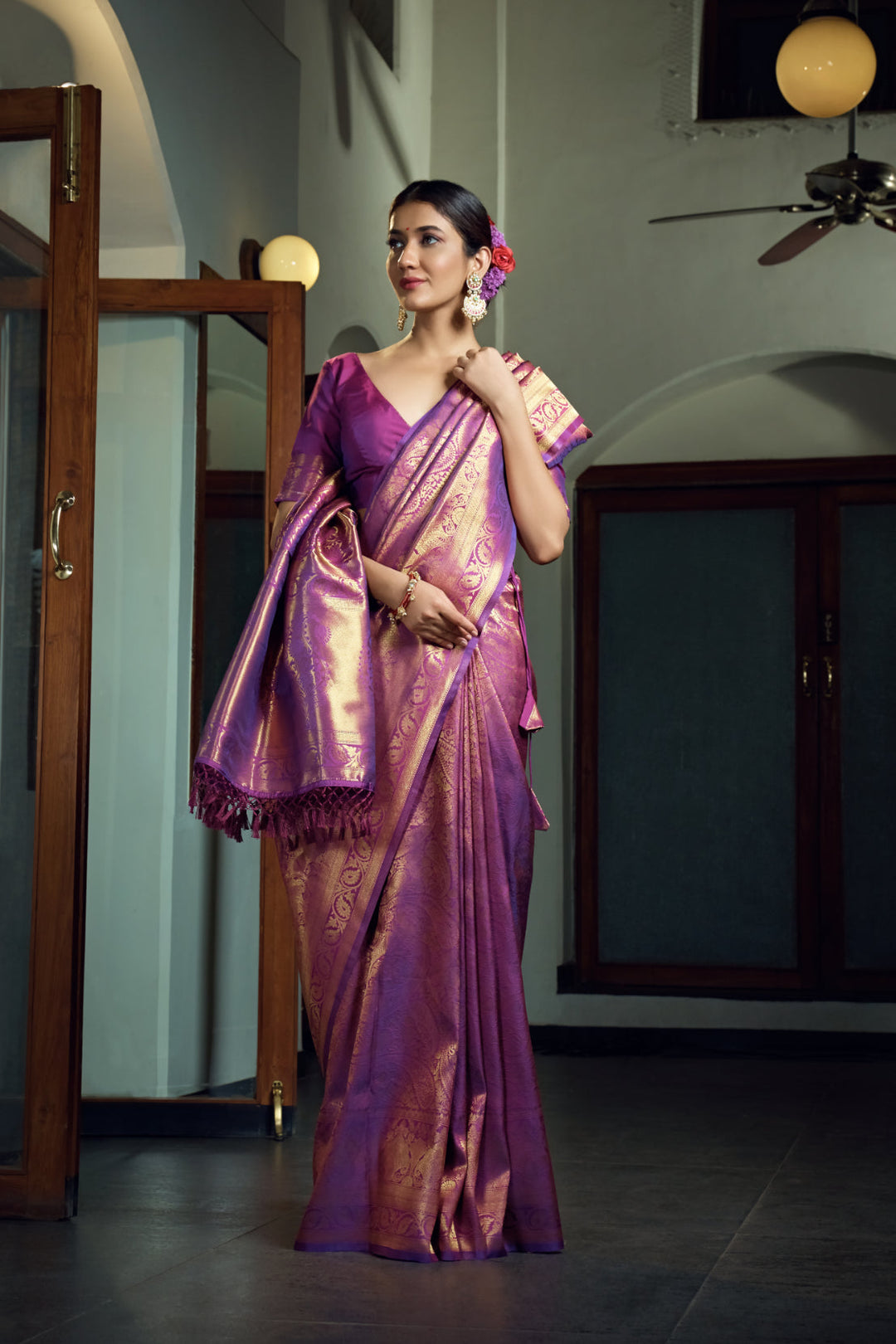 Close-up of mango and floral motifs in shimmering gold zari against the rich purple fabric.