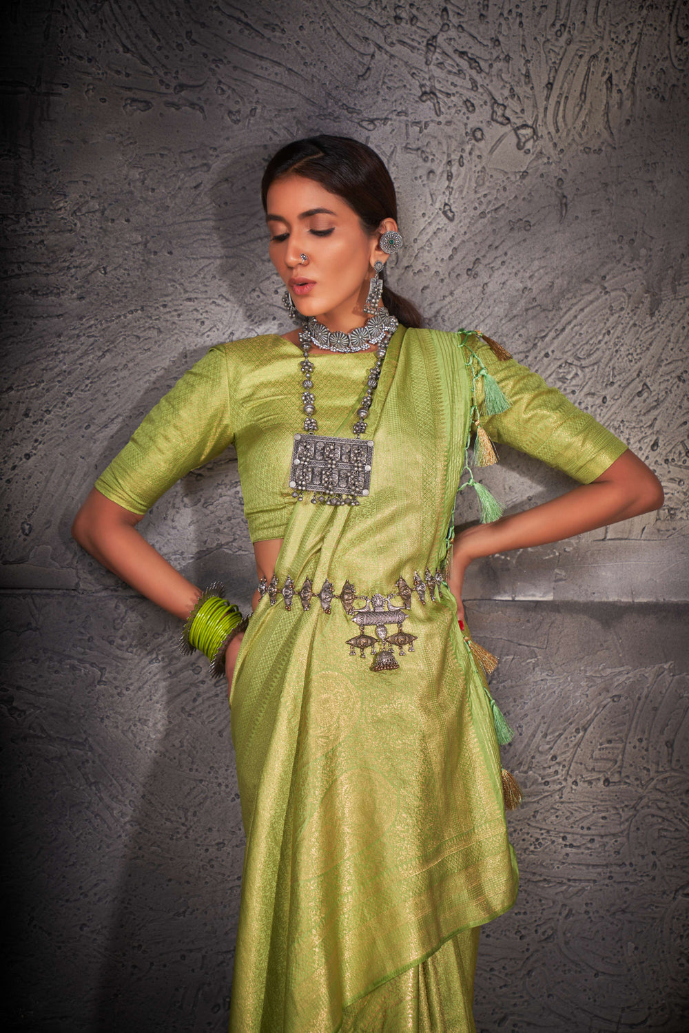 Close-up of intricate gold zari work on the saree's border and pallu.