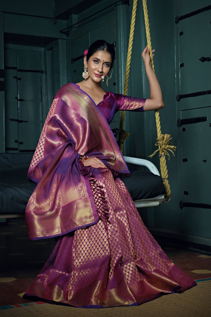 Close-up of intricate gold zari work on the wine-colored pallu.