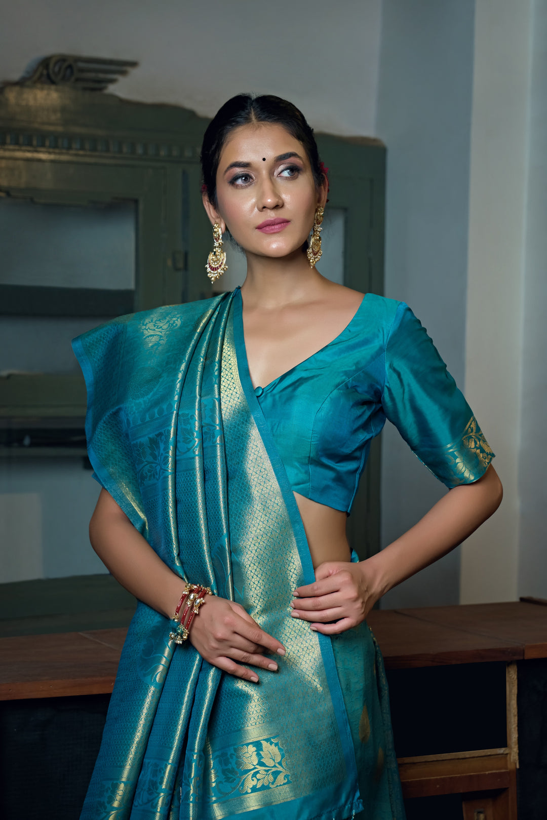 Close-up of the saree’s intricate gold zari work on the border and pallu.