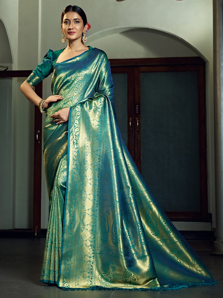 Model draped in Teal Blue Kanjivaram saree highlighting the intricate zari buttas.
