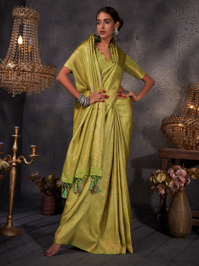 Model draped in yellowish green Kanjeevaram saree with intricate gold, copper, and silver zari details.